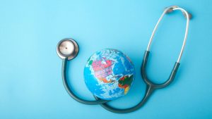 World health day ,Stethoscope wrapped around globe on pastel blue background. Save the wold, Global health care and Green Earth day concept